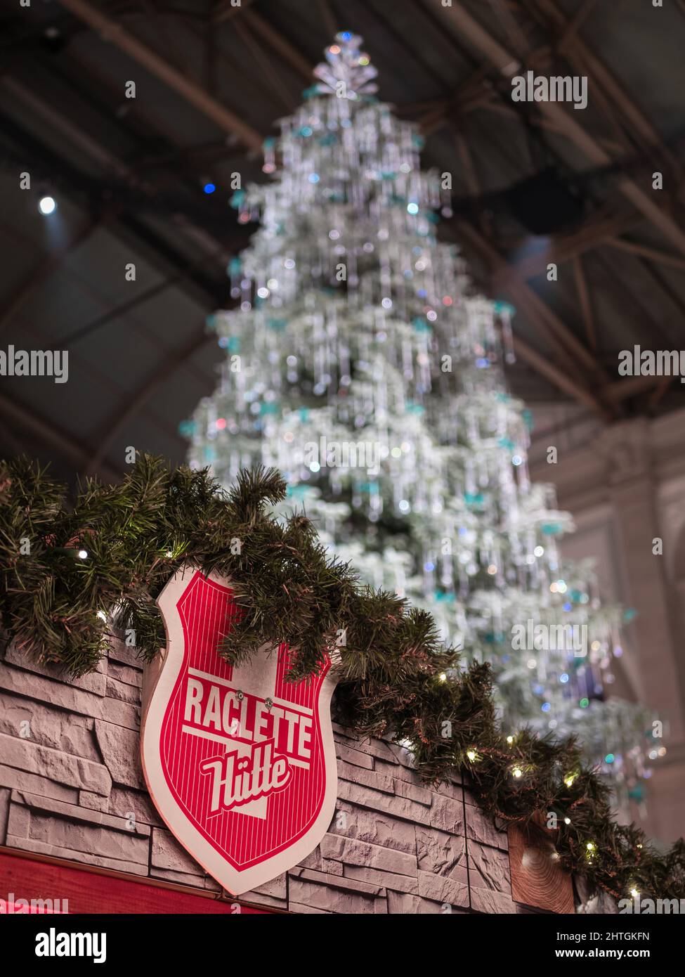 Zurich, Suisse - 30 novembre 2021 : un vendeur de raclette se trouve sous un arbre de Noël traditionnel Swarovski à la gare de Zurich Banque D'Images