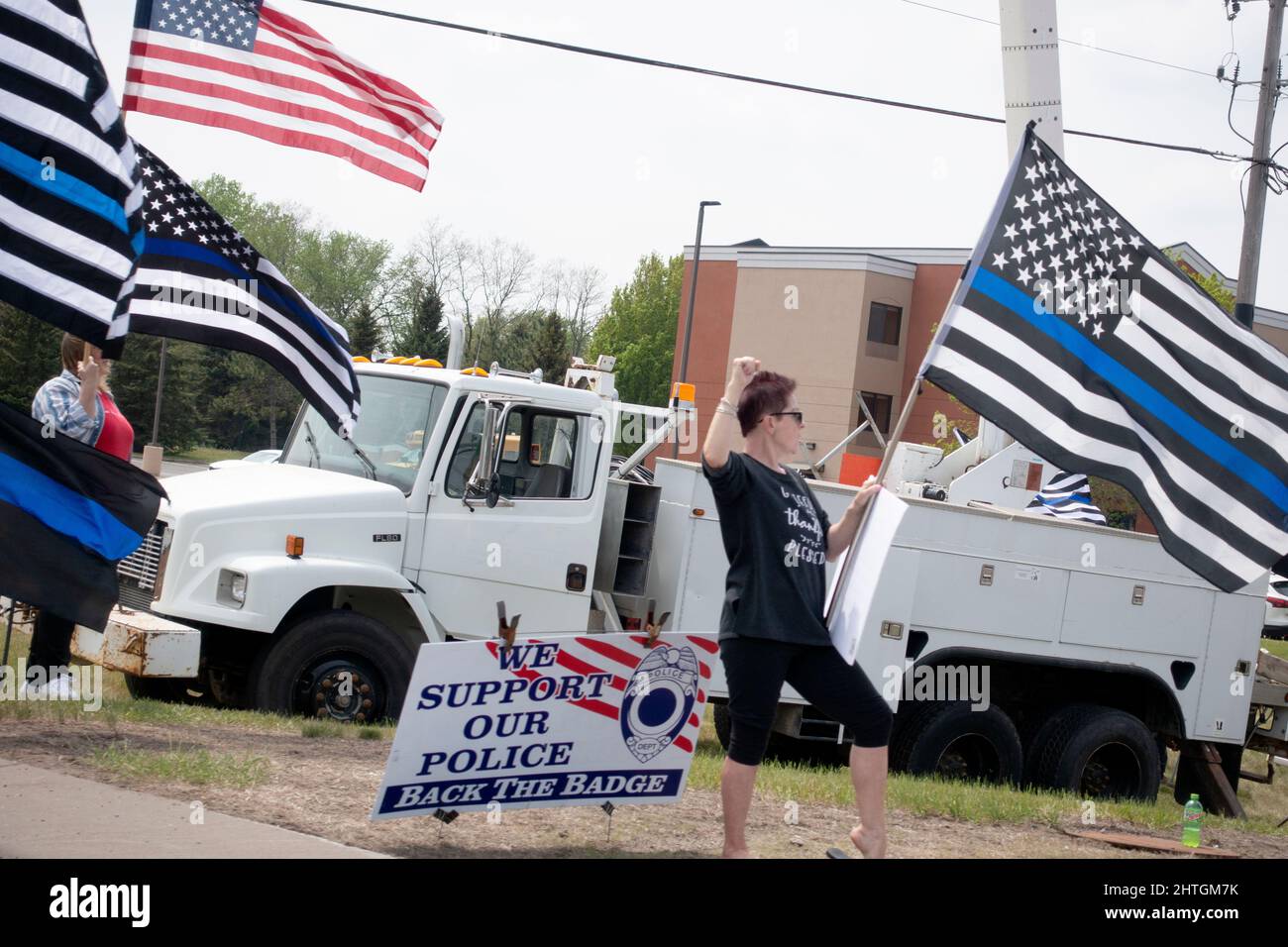 Femmes avec drapeau américain et drapeaux avec une ligne bleue pour soutenir la police manifestant le long de la route. Anoka Minnesota MN États-Unis Banque D'Images
