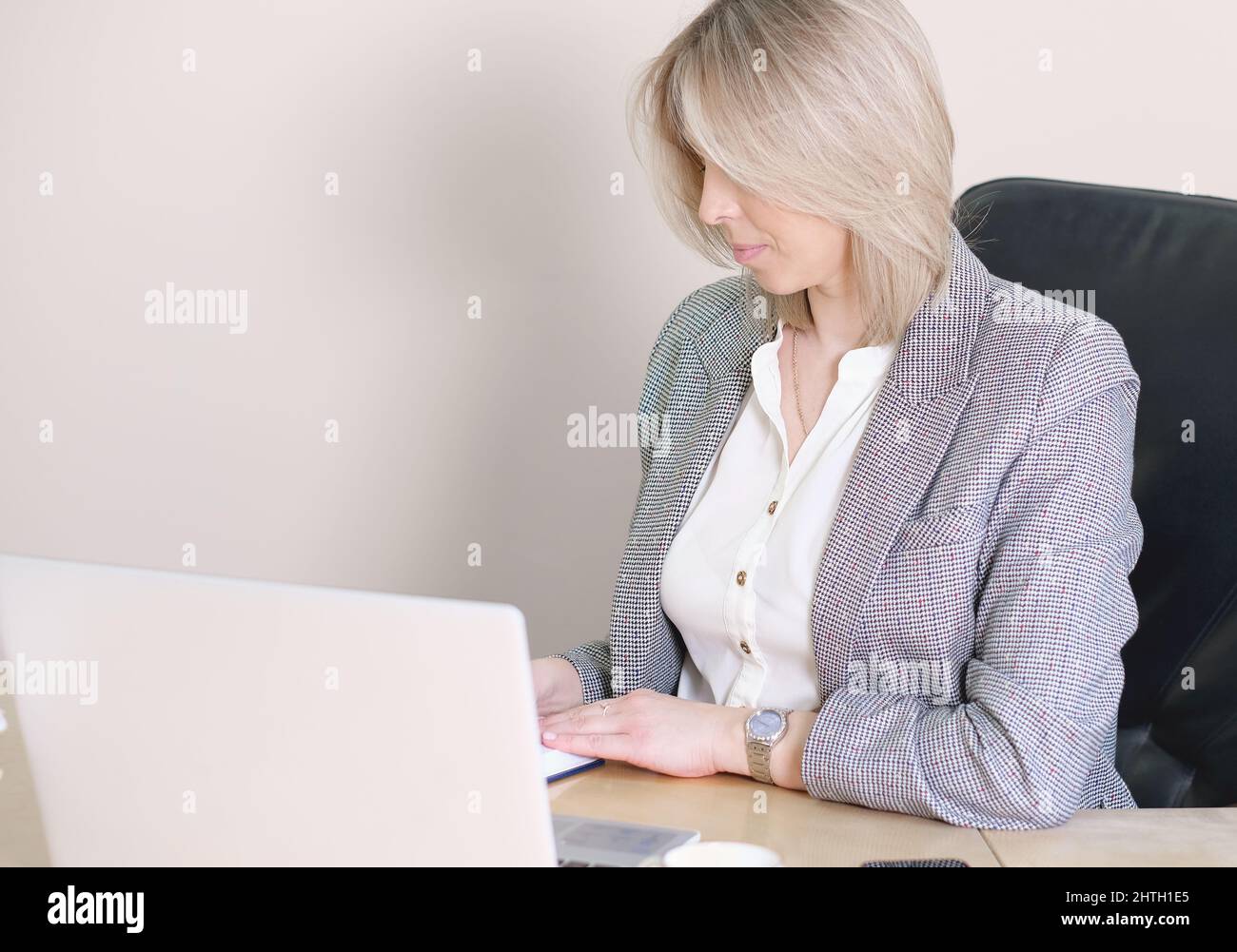 femme assise au bureau tenant un stylo écrivant dans le bloc-notes portant des vêtements formels dans le bureau à l'intérieur. planification de la nouvelle création d'entreprise. investisseur d'affaires féminin Banque D'Images