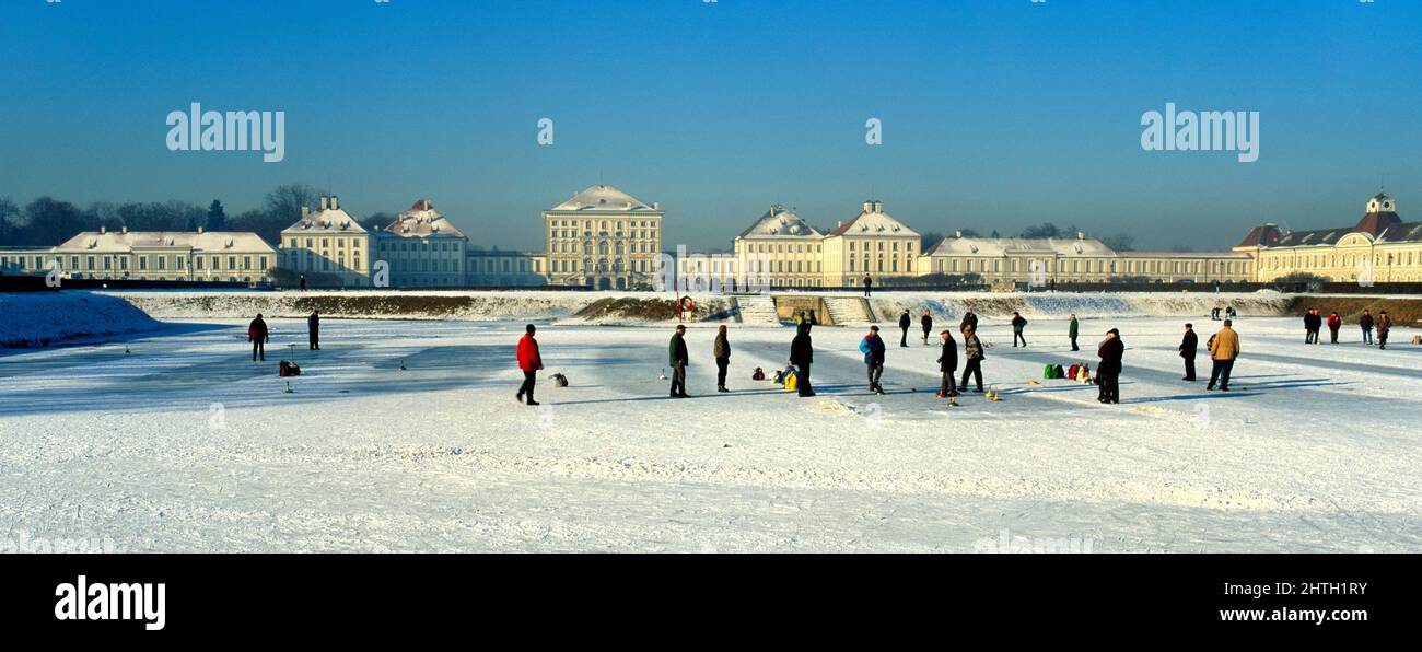 Hommes jouant le jeu Eisstock ( icestick ) sur le lac gelé du palais de Nymphenburg, Munich, haute-Bavière, Allemagne Banque D'Images