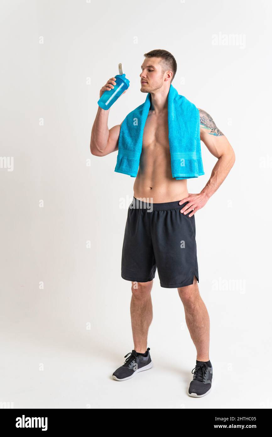 La forme physique masculine de boisson-eau est pompée avec une serviette sur un fond blanc isolé athlète fort style de vie, eau saine jeune homme gars, briser l'hydratation Banque D'Images