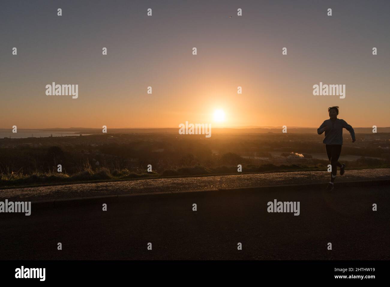 Édimbourg, Écosse, Royaume-Uni, 1st mars 2022. Météo au Royaume-Uni : Edimbourg se réveille un matin ensoleillé. Une personne qui marche un chien autour de Arthur's Seat. Siège d'Arthur. ArCredit: Lorenzo Dalberto/Alamy Live News Banque D'Images