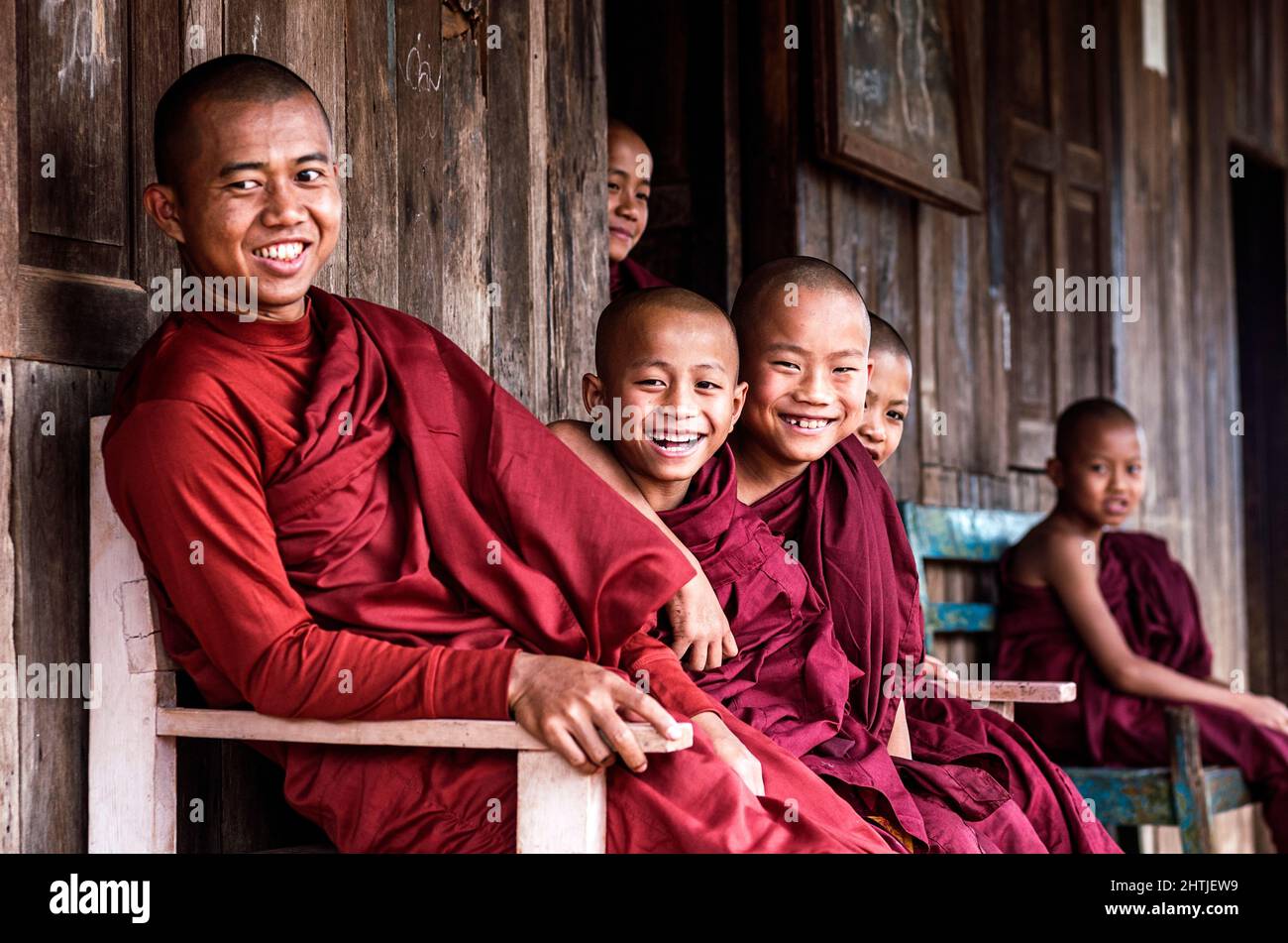 Yangon, Myanmar - 04.16.2017: Drôle de garçon chauve s'amuser avec les enfants portant des robes de moine bouddhiste dans le temple Banque D'Images