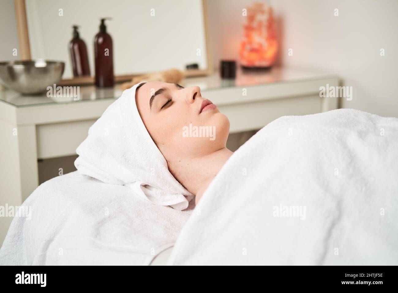 Tout le corps de la femme positive propriétaire avec bâton de bois jouant avec le chien noir sur la côte sablonneuse près de la mer dans la station tropicale Banque D'Images