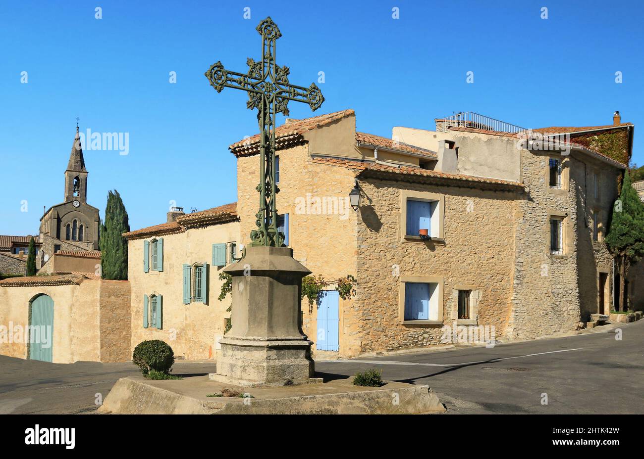 Croix monumentale sur la place d'un village provençal. Banque D'Images