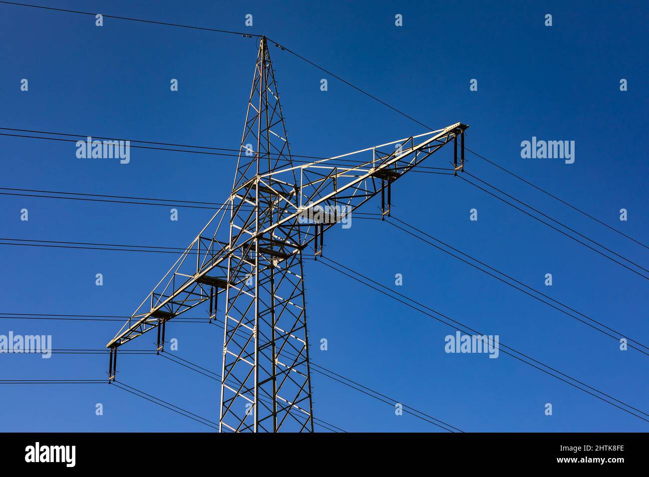 Un grand poteau de puissance contre le ciel bleu avec de nombreuses lignes de puissance Banque D'Images