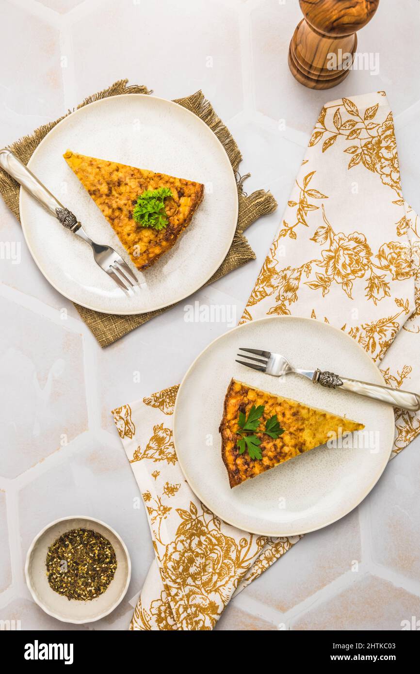 Deux morceaux d'un gâteau de pommes de terre, tortilla espagnole, frittata, sur fond blanc, vue de dessus, verticale Banque D'Images