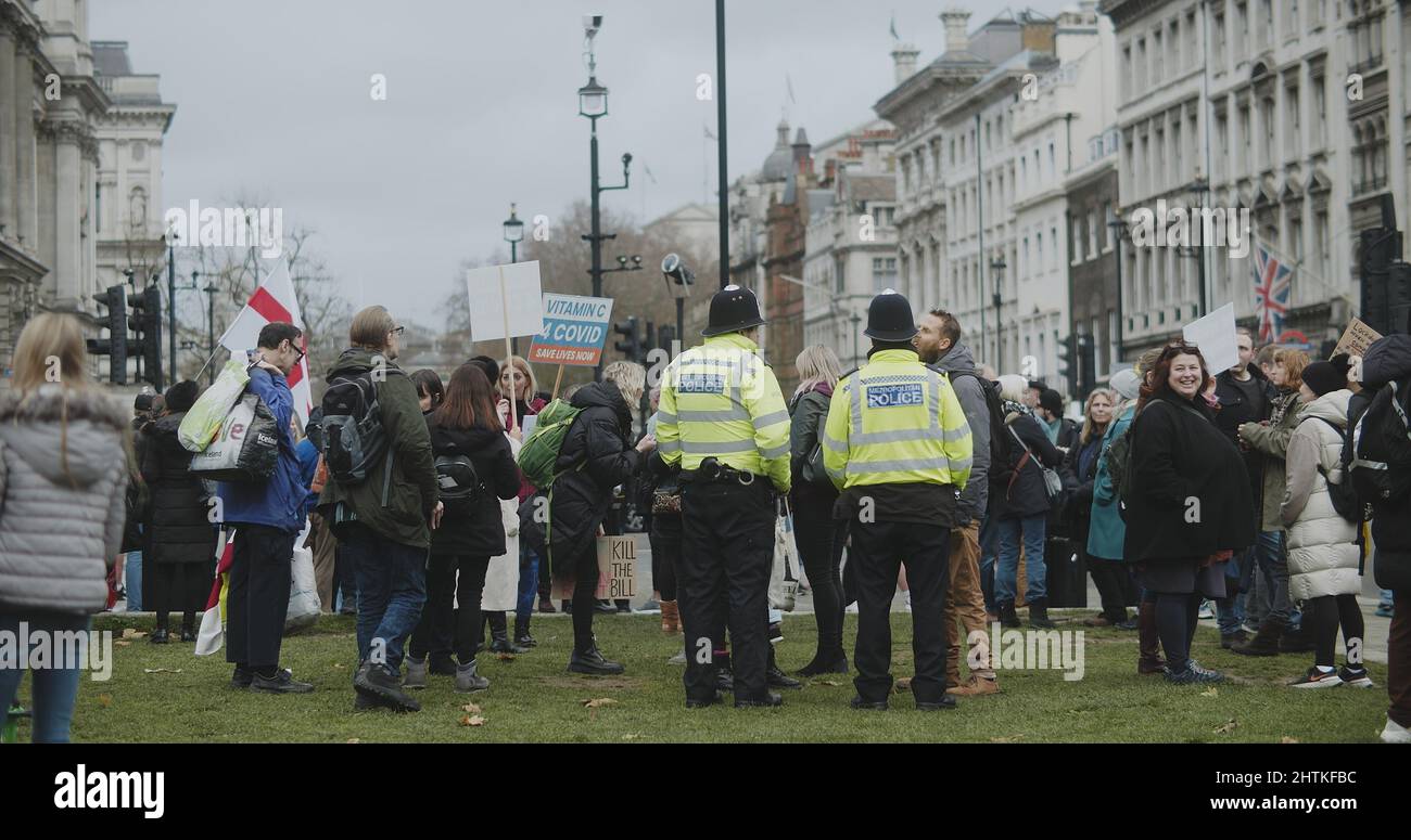 Londres, Royaume-Uni - 12 13 2021: A rencontré des policiers en service parmi une foule de manifestants tenant des signes d'un rassemblement de liberté et de lutte contre la vaccination. Banque D'Images