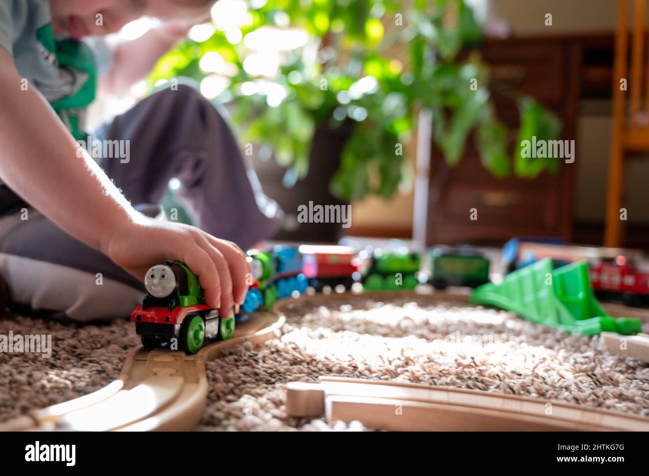 Tiffin, Iowa, Etats-Unis - 3.2021: Petit garçon jouant avec un modèle Thomas le train.Thomas est un jouet populaire sur le thème du chemin de fer pour enfants. Banque D'Images