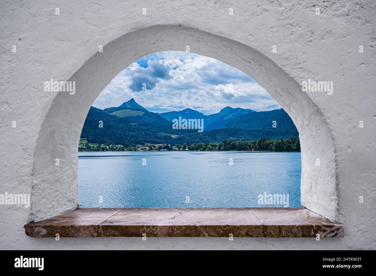 Vue à travers une fenêtre en pierre sur le magnifique paysage du Wolfgangsee en Autriche Banque D'Images
