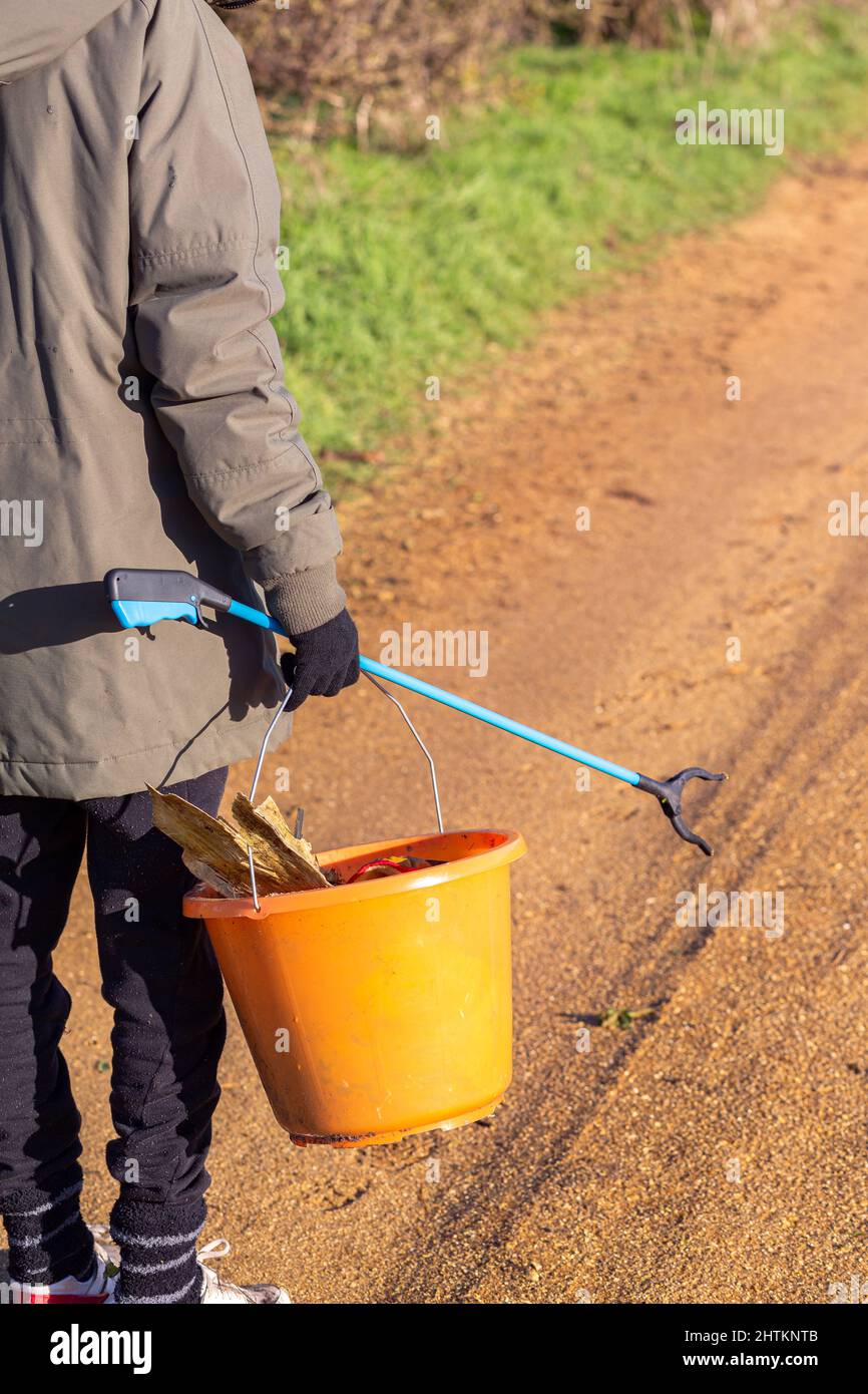 Une personne inconnue portant un picker de litière et un seau prêt à faire un picker de litière. Collecte de litière, déchets, concept environnemental Banque D'Images