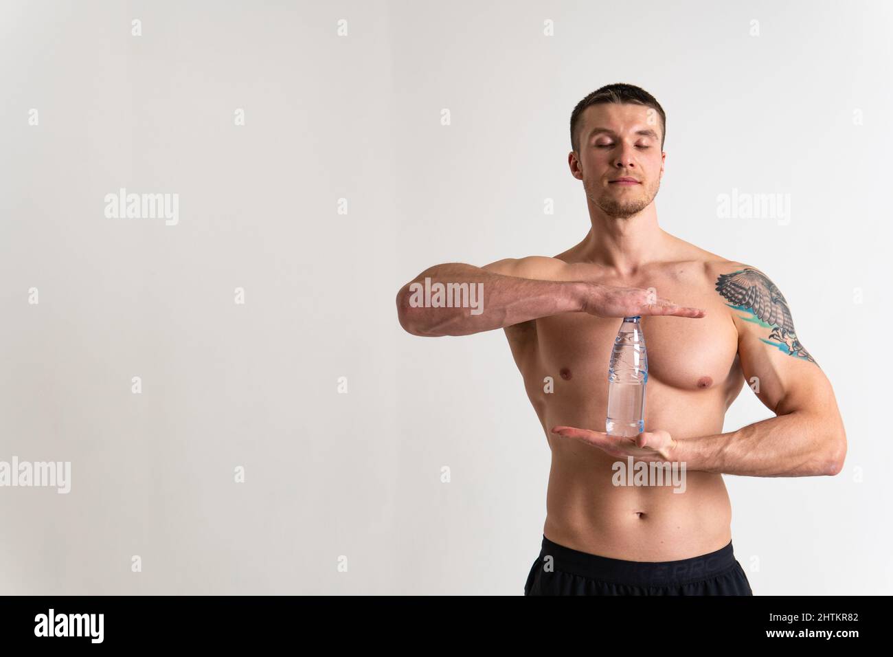 La forme physique à l'eau potable est pompée avec une serviette sur un fond blanc santé musculaire isolée, hydratation de la nutrition masculine. Protéine de force active Banque D'Images