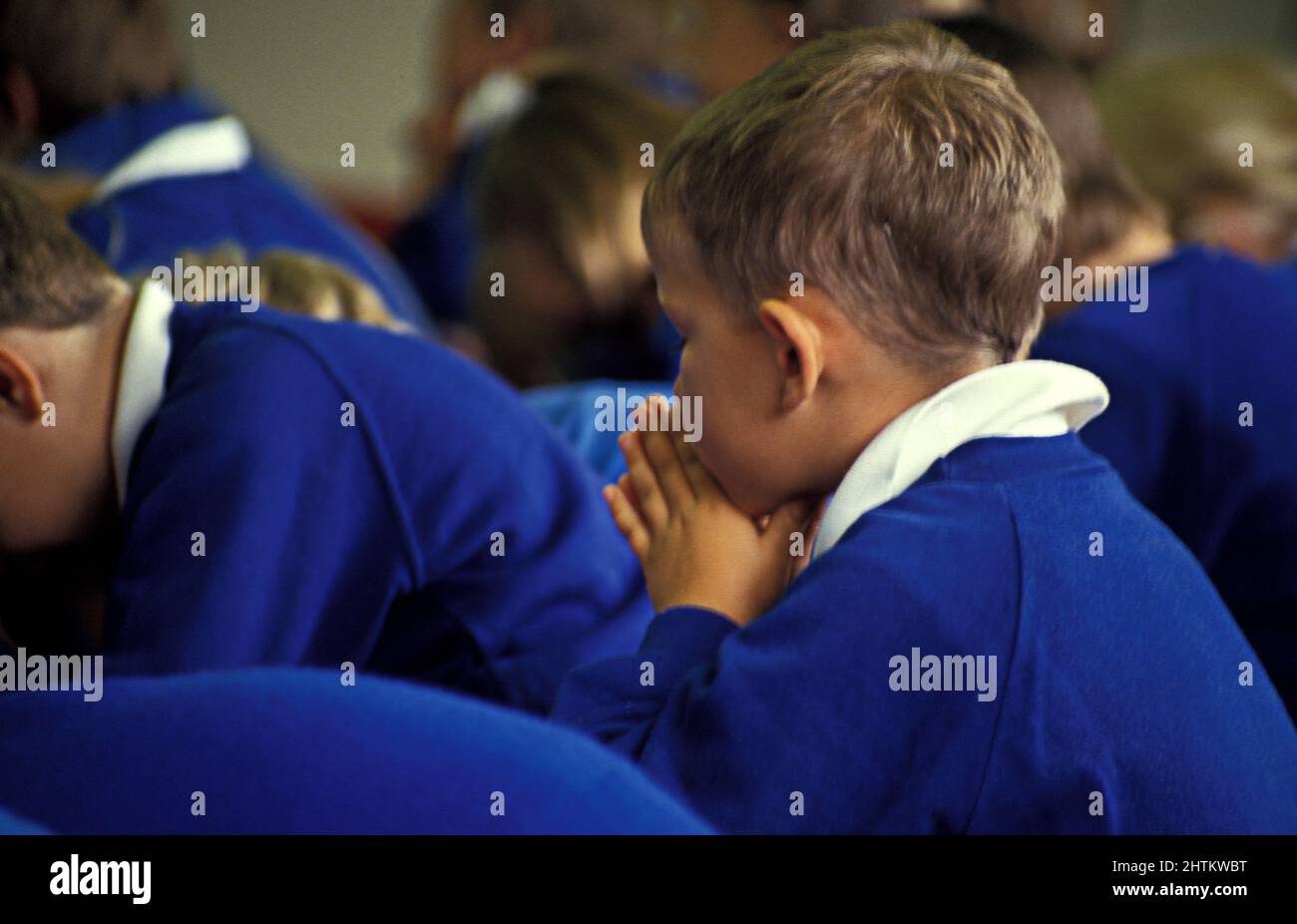 les enfants de l'école primaire prient en assemblée Banque D'Images