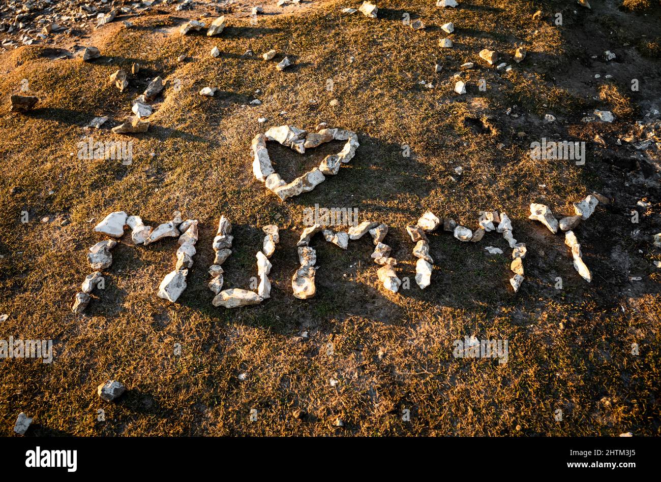 Le mot « Mummy » et une forme de coeur sont faits de galets de flan sur le promontoire de Birling Gap, un site de beauté naturelle sur la côte sud de l'Angleterre Banque D'Images