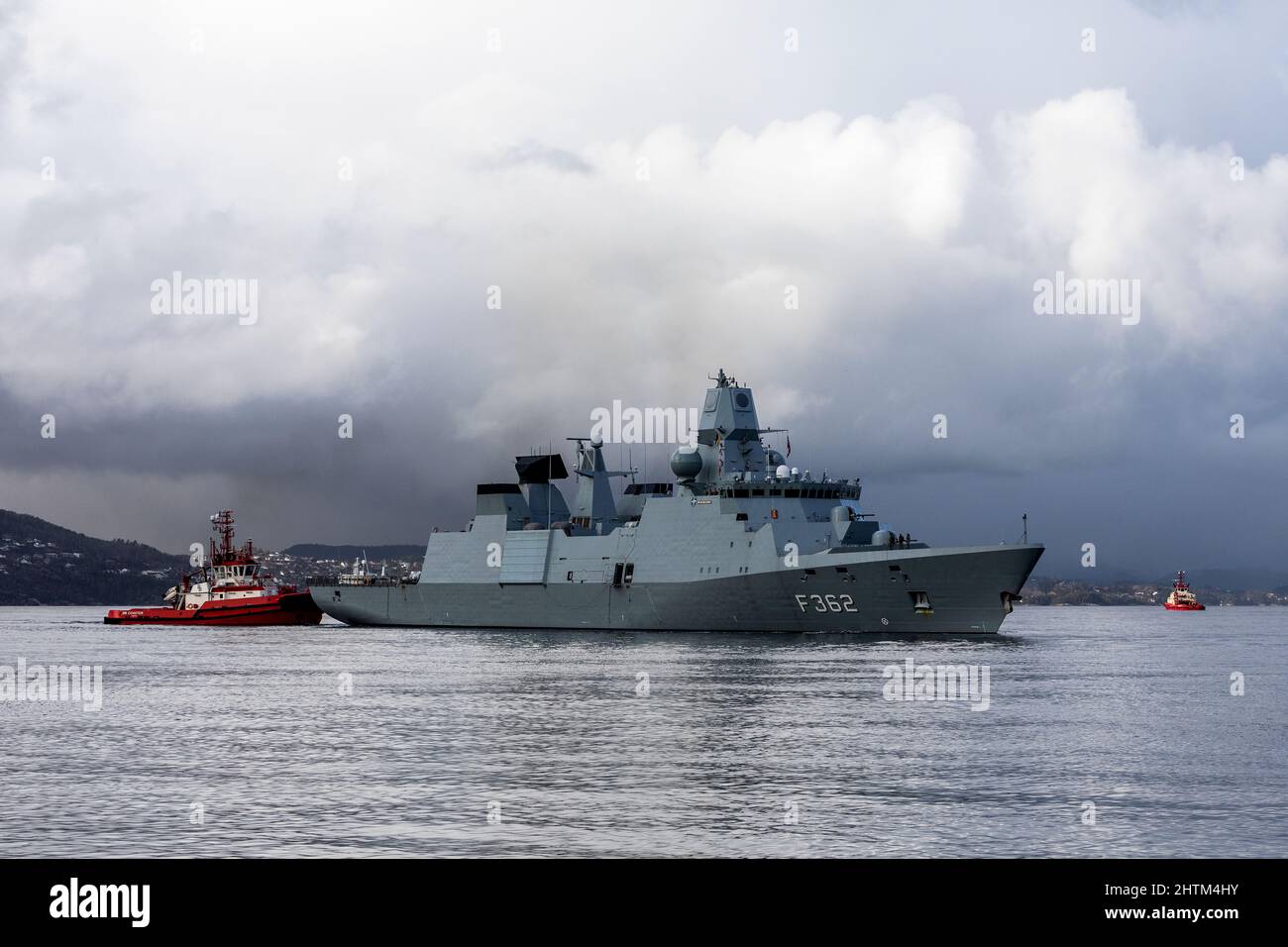 Frégate de classe Huitfeldt danoise F362 HDMS Peter Willemoes à Byfjorden, au large du port de Bergen, en Norvège. Bateau de plaisance BB Coaster à proximité. Un noir, pluvieux Banque D'Images