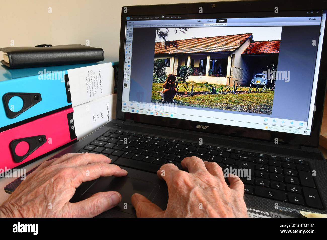 Les vieilles mains à un clavier d'ordinateur trouver des images pour déclencher des souvenirs agréables à mesure que l'on vieillit.la vie en tant qu'expatrié travaillant en Zambie pendant le 19 Banque D'Images