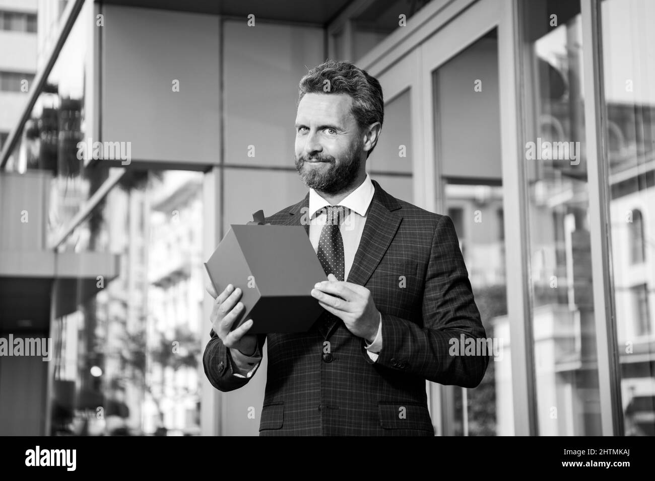 Homme d'affaires à l'extérieur avec sacs à provisions.Beau homme avec cadeau d'anniversaire.Célébration d'anniversaire.Salutations vacances.Boutique de cadeaux. Banque D'Images