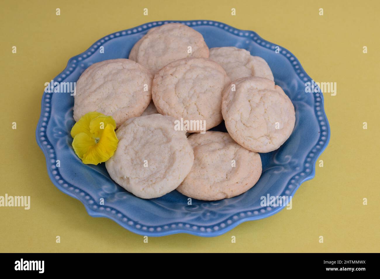 Biscuits au thé du Sud faits maison présentés sur une assiette bleue avec une pansy jaune. Banque D'Images