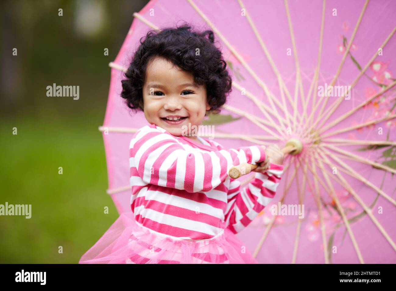 Vous aimez mon parapluie. Adorable petite fille jouant avec un parapluie en papier pendant qu'à l'extérieur. Banque D'Images