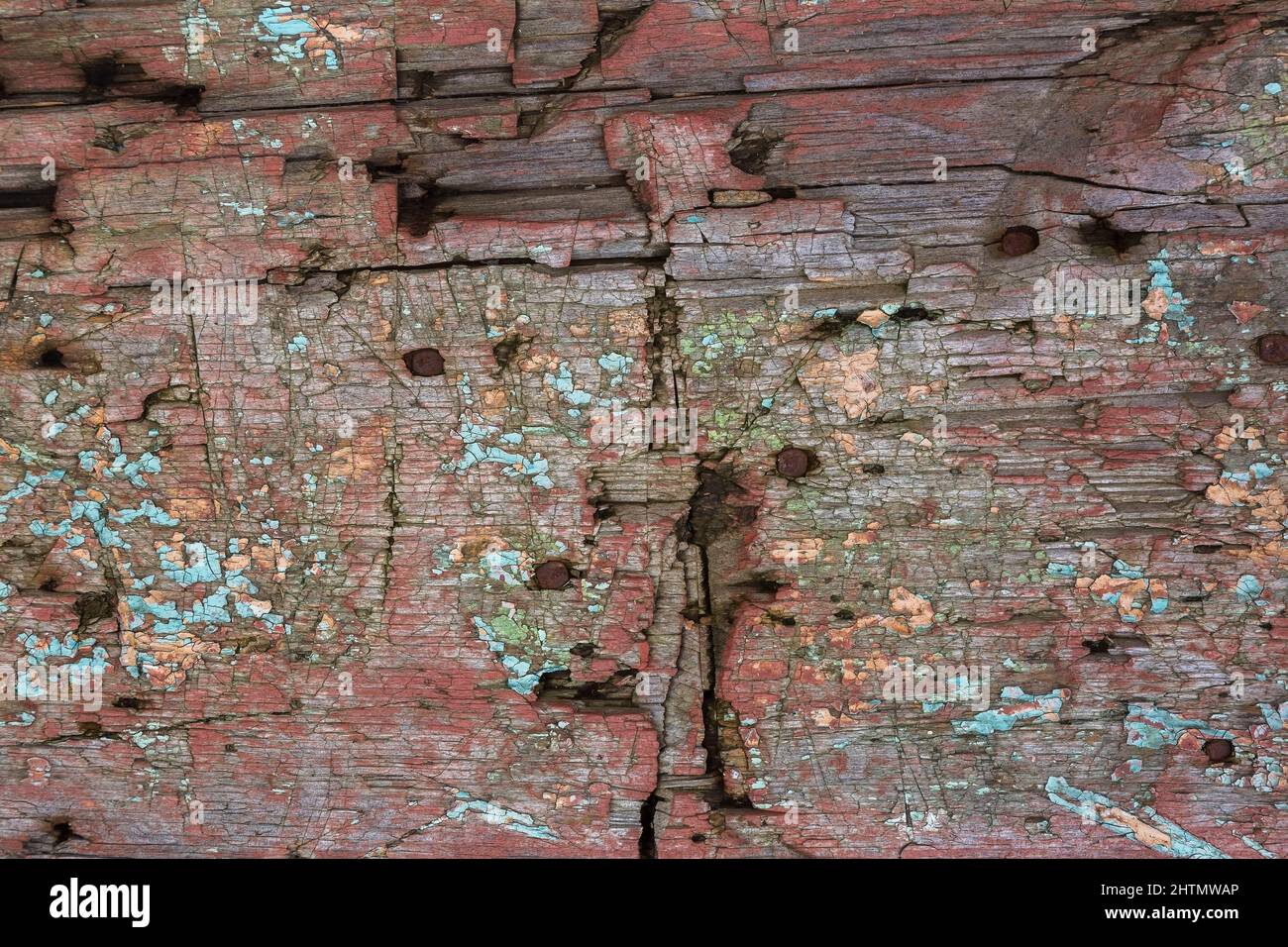 Surface en bois fissurée, écaillée et décolorée peinture rouge, bleue et turquoise. Banque D'Images