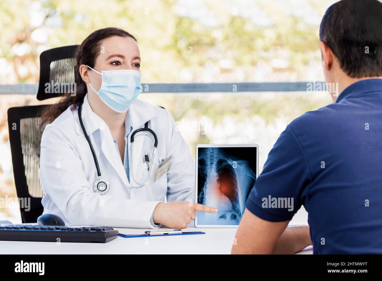 Prise de vue d'une jeune femme médecin utilisant une tablette numérique lors d'une consultation avec un homme mature souffrant de long covid Banque D'Images