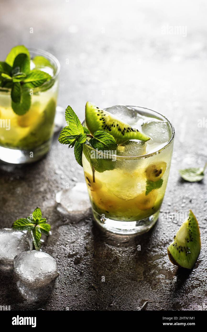 Deux cocktails frais et glacés avec kiwi et menthe sur fond texturé Banque D'Images