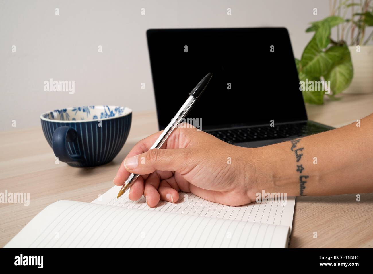 Gros plan de la main de la femme écrivant dans le bloc-notes Banque D'Images