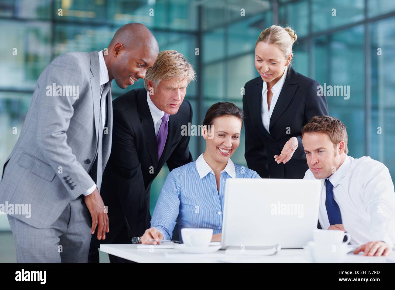 Consulter leurs derniers rapports de stock. Une équipe positive de collaborateurs travaillant ensemble. Banque D'Images