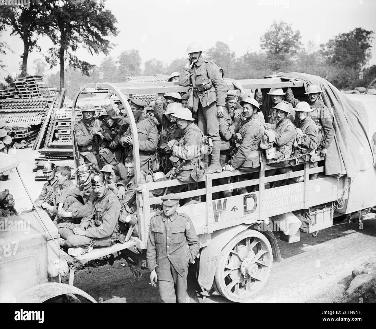 Colonne de camions avec des hommes de la Division irlandaise 16th (probablement mélange de troupes de divers régiments de la Brigade 47th) qui reviennent pour un repos après avoir pris Guillemont, le 3 septembre 1916. Ils passent par le poste de la Minden sur la route de Fricourt-Maricourt, à l'ouest-sud-ouest de Carnoy. Notez quelques soldats portant des pickelhaubes allemands capturés. Banque D'Images