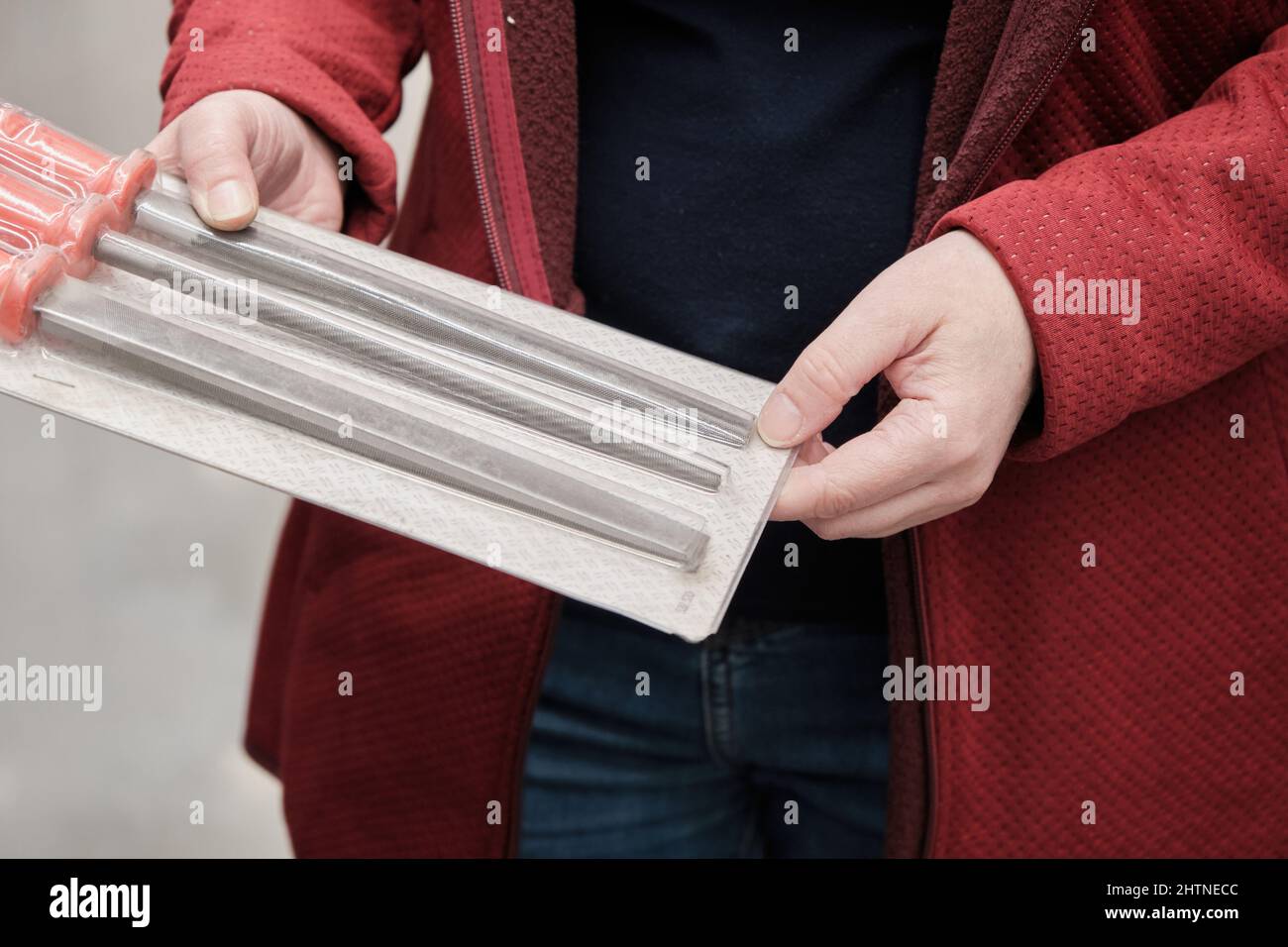 La femme en magasin de matériaux de construction achète nadfils et rassps de formes différentes Banque D'Images