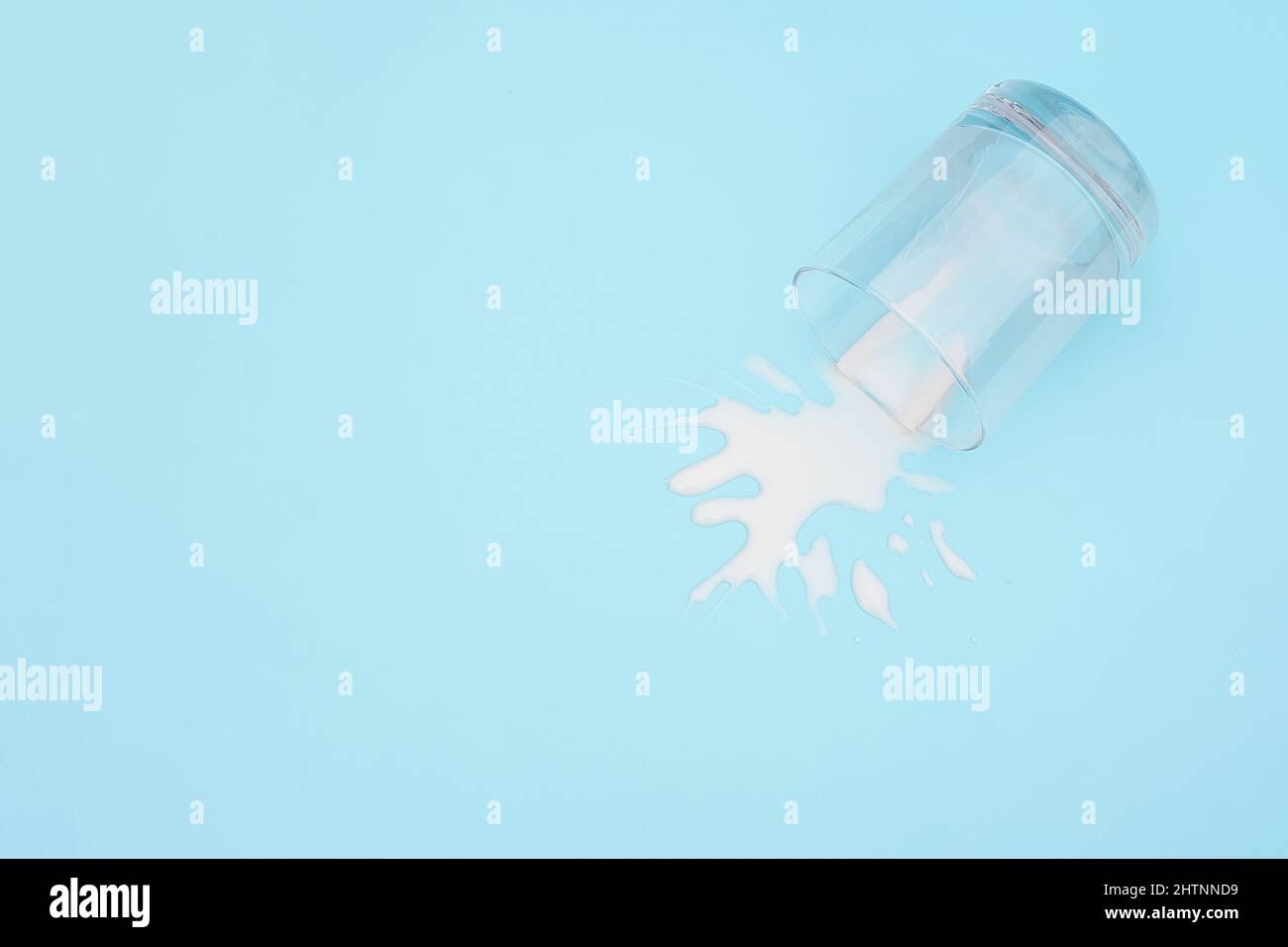 Lait renversé. Verre renversé avec lait sur fond bleu. Concept d'abandon des produits laitiers espace de copie vue de dessus. Banque D'Images Lait renversé. Verre renversé avec lait sur fond bleu. Concept d'abandon des produits laitiers espace de copie vue de dessus. Banque D'Images