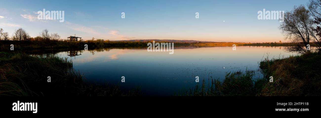 Panorama du lac d'automne. Réflexion miroir dans l'eau, ciel bleu. Banque D'Images