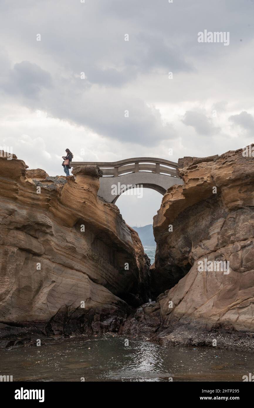 Femme asiatique lit une carte au bord d'un pont à Yehliu Geopark, New Taipei City, Taiwan, ROC Banque D'Images