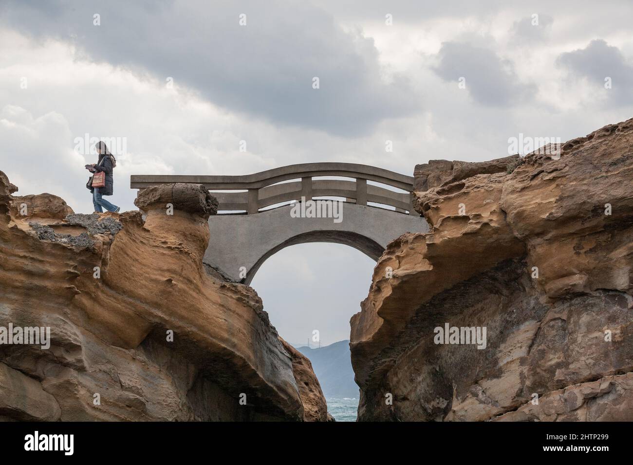 Femme asiatique lit une carte au bord d'un pont à Yehliu Geopark, New Taipei City, Taiwan, ROC Banque D'Images