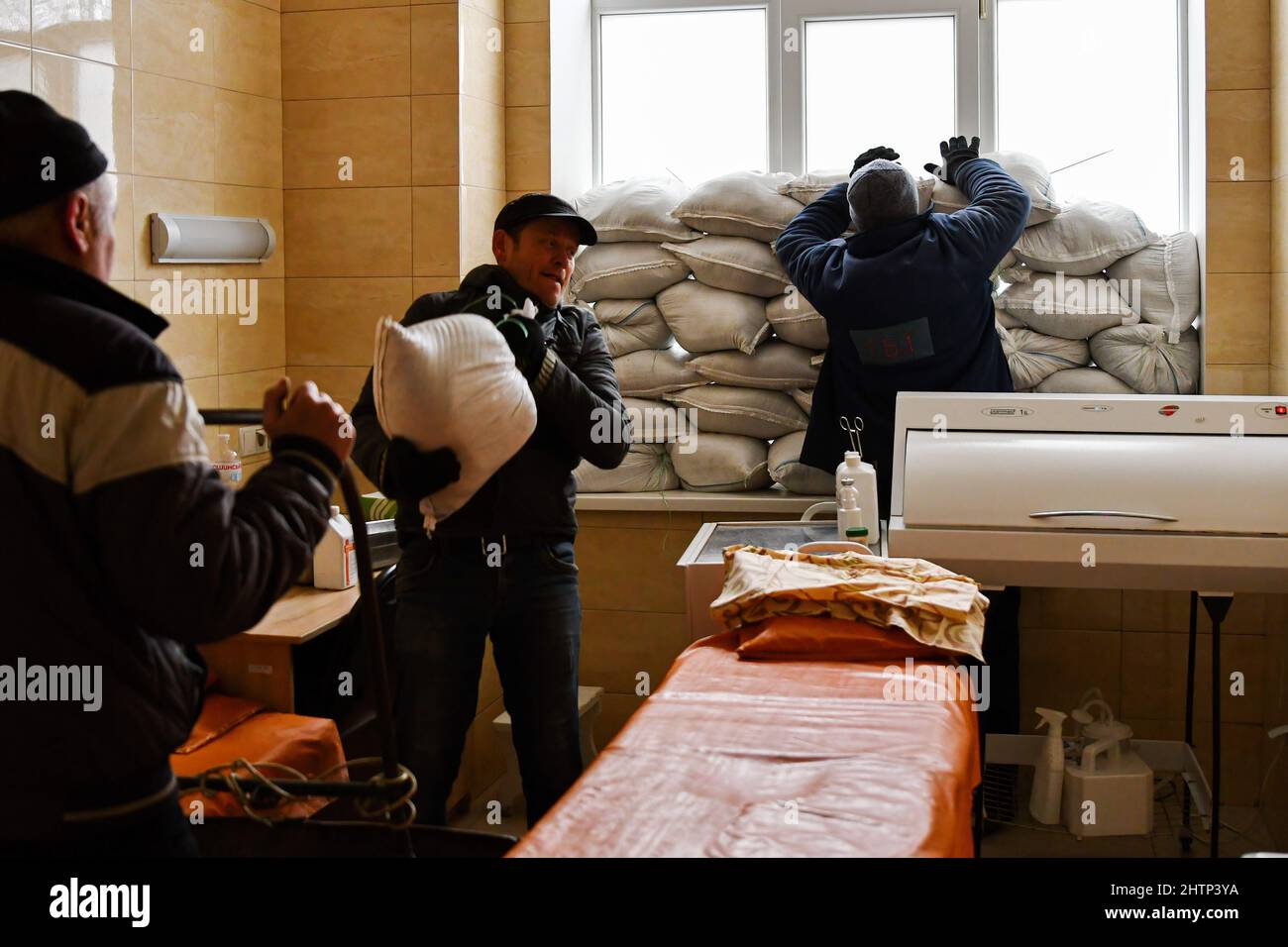 Kramatorsk, Ukraine, 1/3/2022, les travailleurs placent des sacs de sable près de la fenêtre pour la protection dans l'hôpital de la ville de Kramatorsk. Le président russe Vladimir Poutine a ordonné l'intervention militaire le 24 février, quelques jours après avoir reconnu deux enclaves séparatistes dans l'est de l'Ukraine. Il a affirmé que Moscou n'avait aucun plan pour occuper le pays voisin mais voulait "démilitariser" et "dénaziser" l'Ukraine. Le président ukrainien Volodymyr Zelenskyy a accusé la Russie d'essayer d'installer un gouvernement fantoche et a déclaré que les Ukrainiens défendront leur pays contre l'agression russe. Banque D'Images