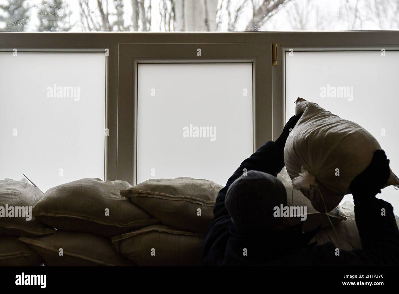 Kramatorsk, Ukraine, 1/3/2022, Un travailleur place des sacs de sable au-dessus de la fenêtre pour la protection dans l'hôpital de la ville de Kramatorsk. Le président russe Vladimir Poutine a ordonné l'intervention militaire le 24 février, quelques jours après avoir reconnu deux enclaves séparatistes dans l'est de l'Ukraine. Il a affirmé que Moscou n'avait aucun plan pour occuper le pays voisin mais voulait "démilitariser" et "dénaziser" l'Ukraine. Le président ukrainien Volodymyr Zelenskyy a accusé la Russie d'essayer d'installer un gouvernement fantoche et a déclaré que les Ukrainiens défendront leur pays contre l'agression russe. Banque D'Images