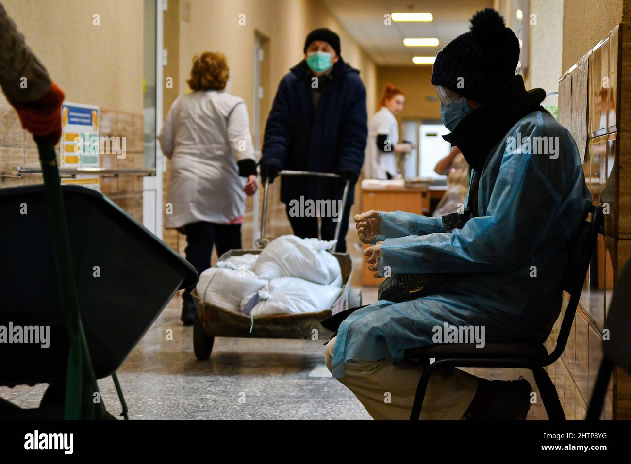 Kramatorsk, Ukraine, 1/3/2022, Un patient est vu assis sur le banc d'attente alors que les travailleurs transportent des sacs de sable pour couvrir la fenêtre de protection dans l'hôpital de la ville de Kramatorsk. Le président russe Vladimir Poutine a ordonné l'intervention militaire le 24 février, quelques jours après avoir reconnu deux enclaves séparatistes dans l'est de l'Ukraine. Il a affirmé que Moscou n'avait aucun plan pour occuper le pays voisin mais voulait "démilitariser" et "dénaziser" l'Ukraine. Le président ukrainien Volodymyr Zelenskyy a accusé la Russie d'essayer d'installer un gouvernement fantoche et a déclaré que les Ukrainiens défendront leur pays contre les Russi Banque D'Images