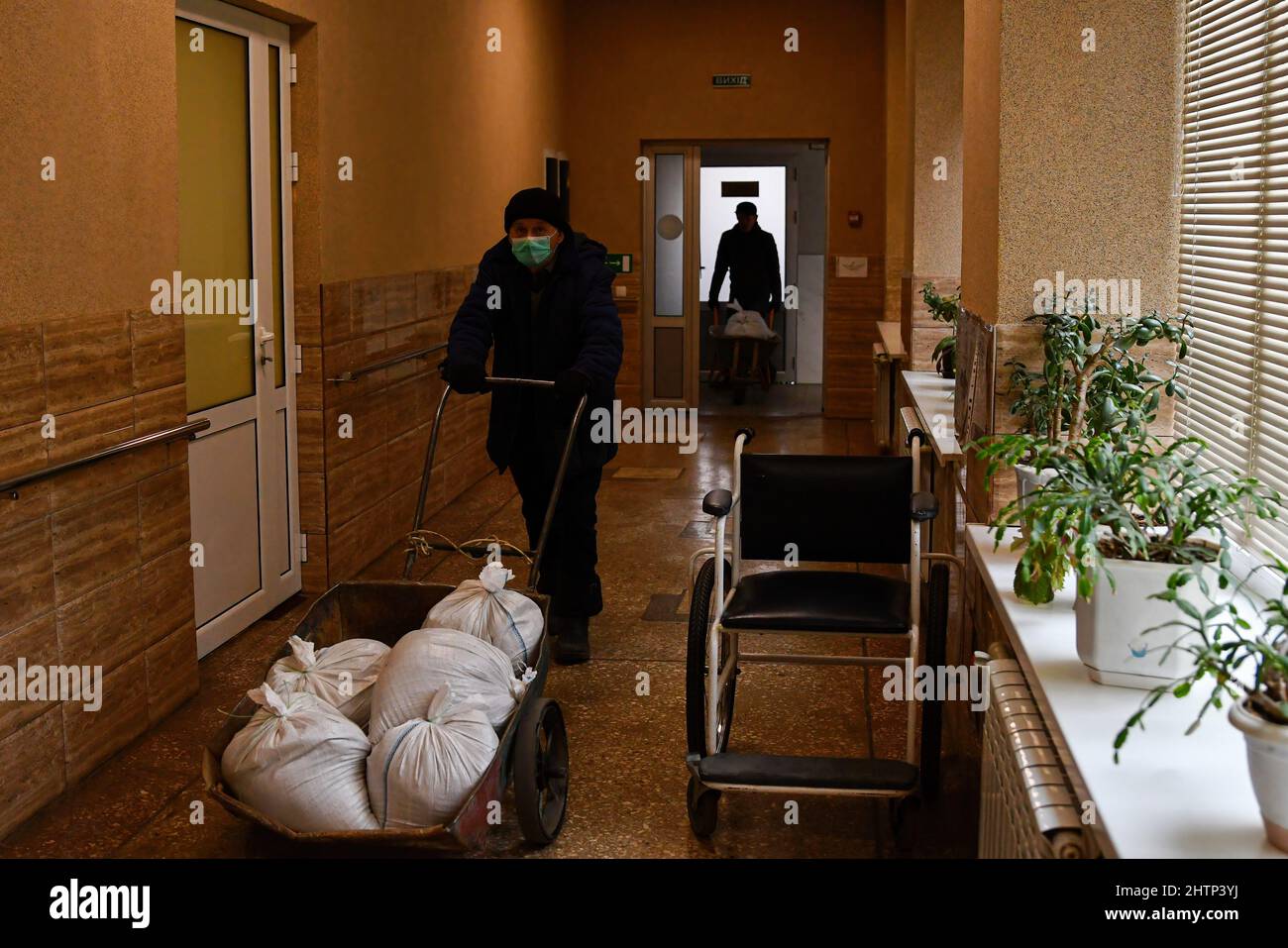 Kramatorsk, Ukraine, 1/3/2022, Un travailleur transporte un sac de sable pour couvrir les fenêtres de l'hôpital afin du protéger dans l'hôpital de la ville de Kramatorsk. Le président russe Vladimir Poutine a ordonné l'intervention militaire le 24 février, quelques jours après avoir reconnu deux enclaves séparatistes dans l'est de l'Ukraine. Il a affirmé que Moscou n'avait aucun plan pour occuper le pays voisin mais voulait "démilitariser" et "dénaziser" l'Ukraine. Le président ukrainien Volodymyr Zelenskyy a accusé la Russie d'essayer d'installer un gouvernement fantoche et a déclaré que les Ukrainiens défendront leur pays contre l'agression russe. Banque D'Images