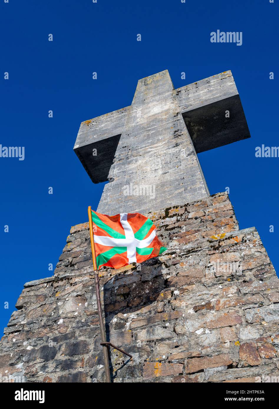 Drapeau du pays Basque volant à côté d'une grande croix de pierre au Parc naturel d'Urkiola dans le pays Basque nord, Espagne Banque D'Images