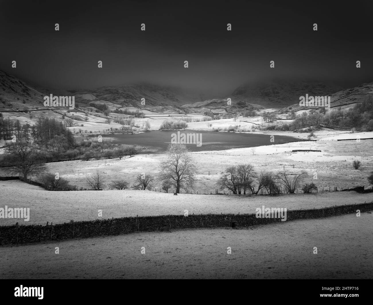Une image infrarouge de Little Langdale Tarn avec les Tillberthwaite Fells et Wrynose est tombée au-delà dans le parc national de English Lake District, Cumbria, Angleterre. Banque D'Images