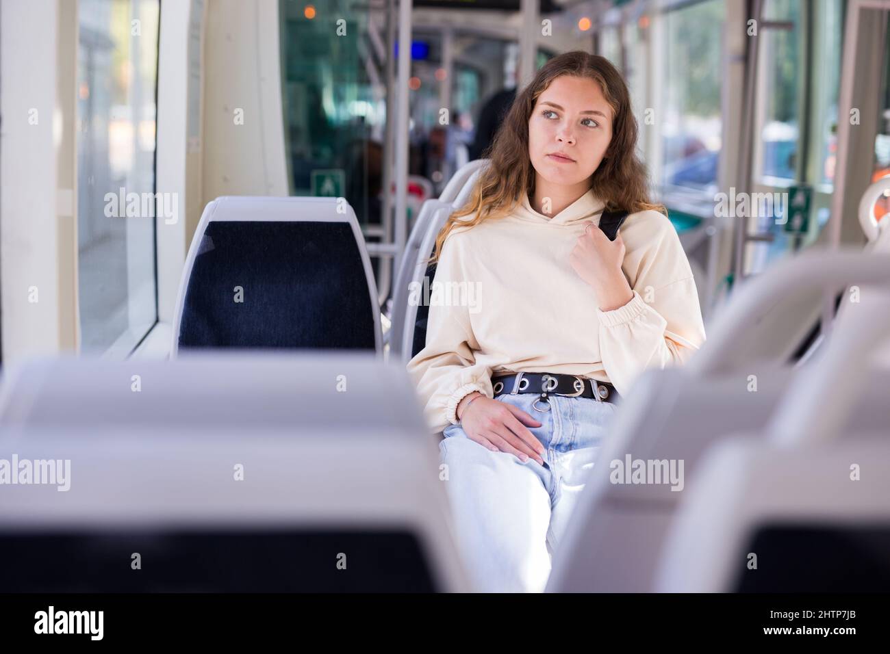 Jeune femme positive voyageant en tram Banque D'Images