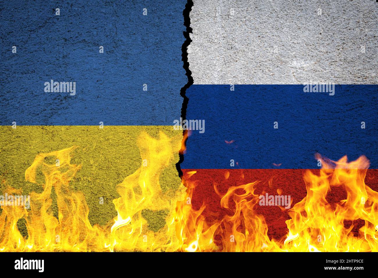 Les drapeaux de l'Ukraine et de la Russie en guerre sur le mur fissuré derrière les flammes Banque D'Images