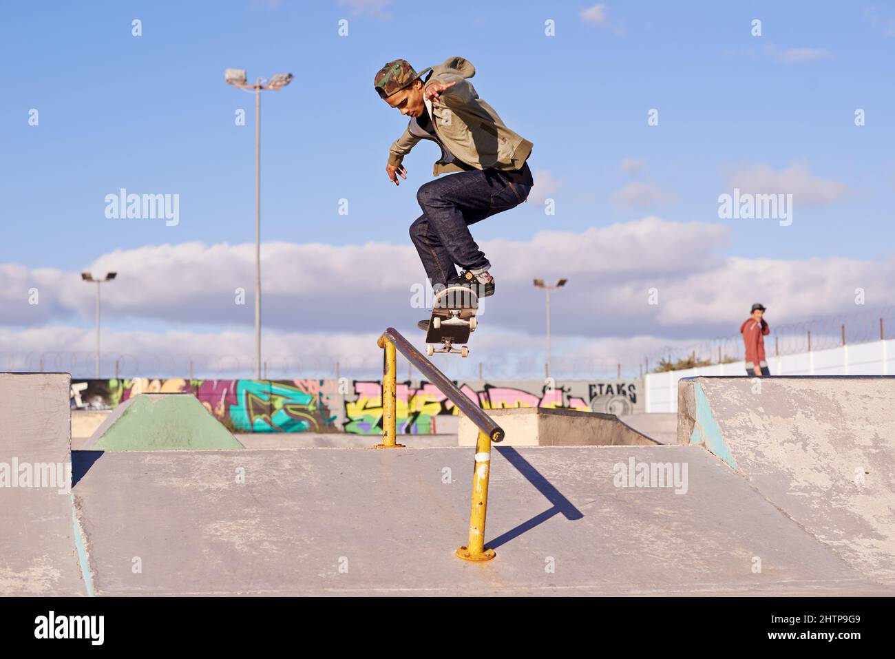 Meuler comme un pro. Photo d'un skateboarder effectuant un tour sur un rail. Banque D'Images