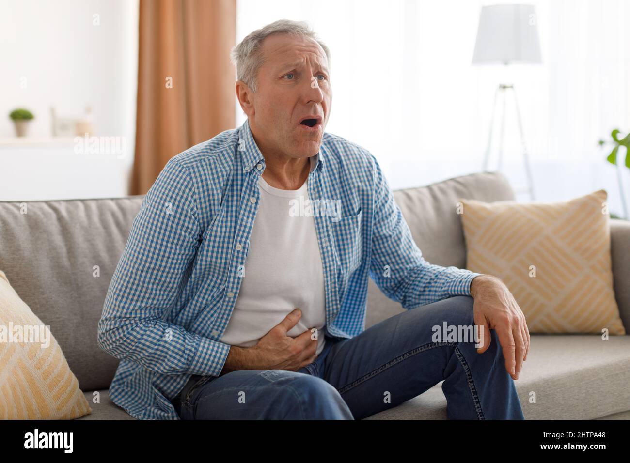 Homme âgé souffrant de maux d'estomac, touchant le ventre Banque D'Images
