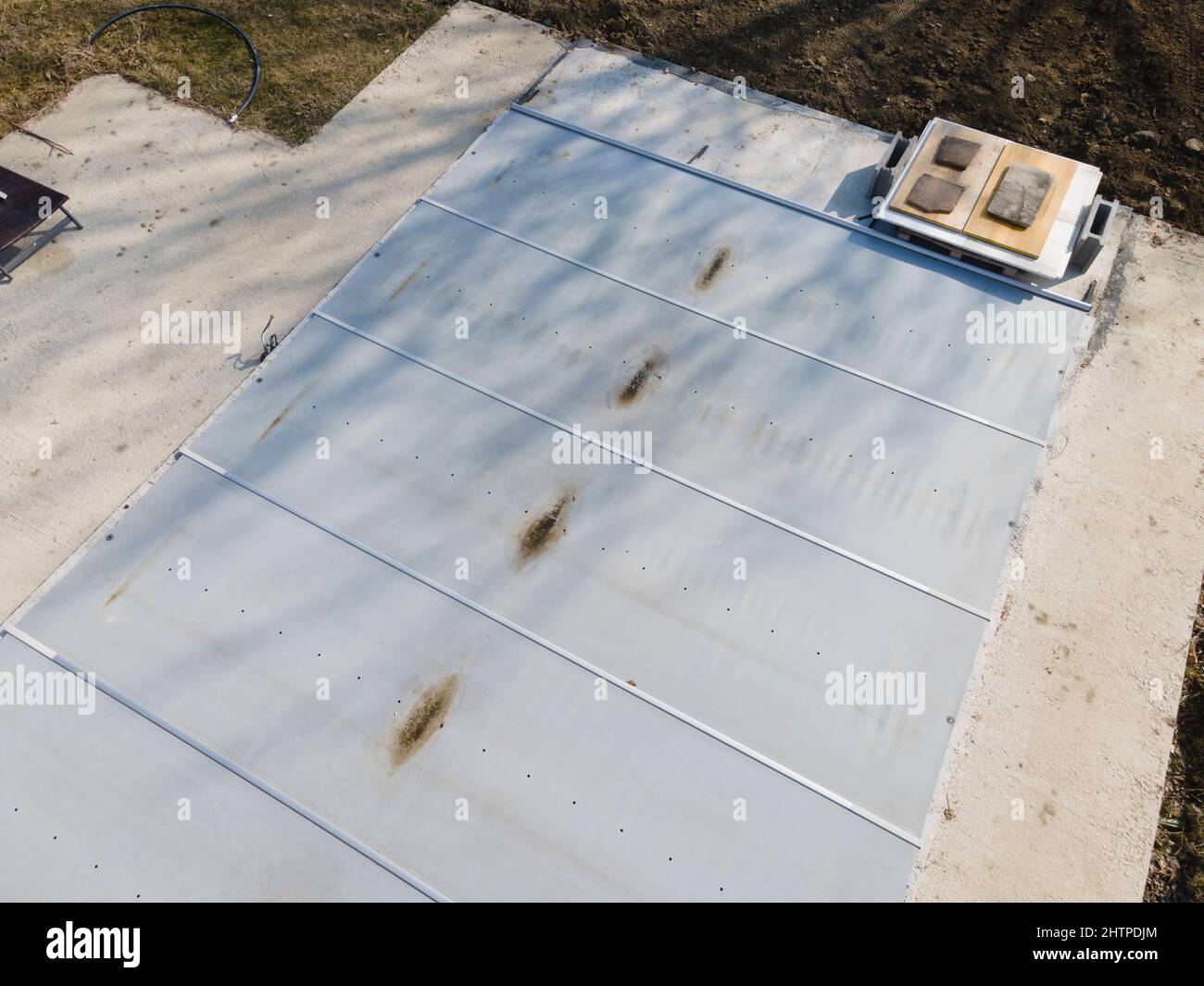 Un drone survolait une piscine couverte avec une bâche encore en construction dans un jardin Banque D'Images