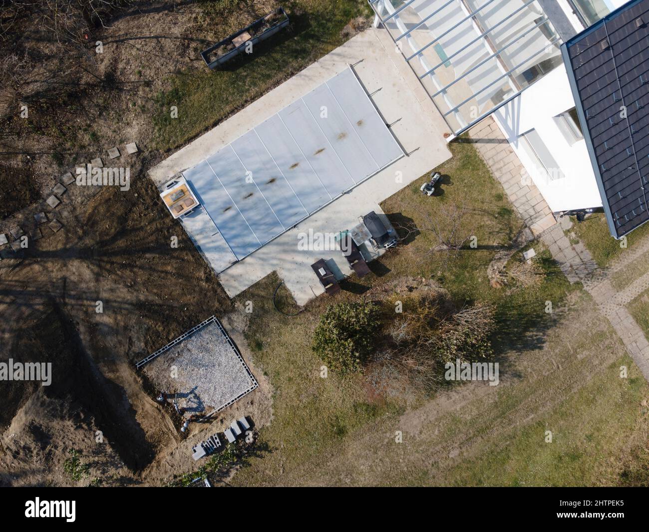 Un drone survolait une piscine couverte avec une bâche encore en construction dans un jardin Banque D'Images