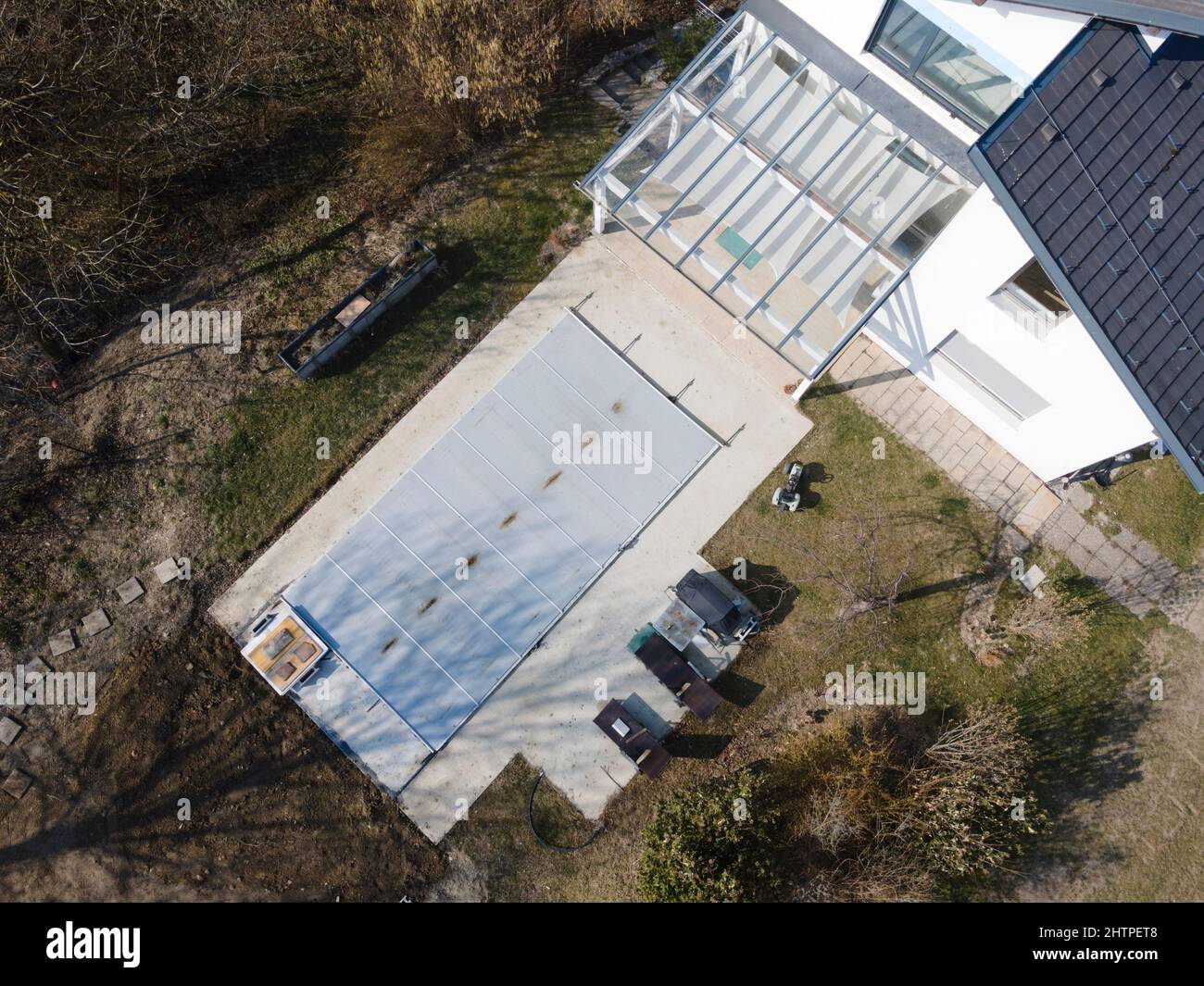 Un drone survolait une piscine couverte avec une bâche encore en construction dans un jardin Banque D'Images