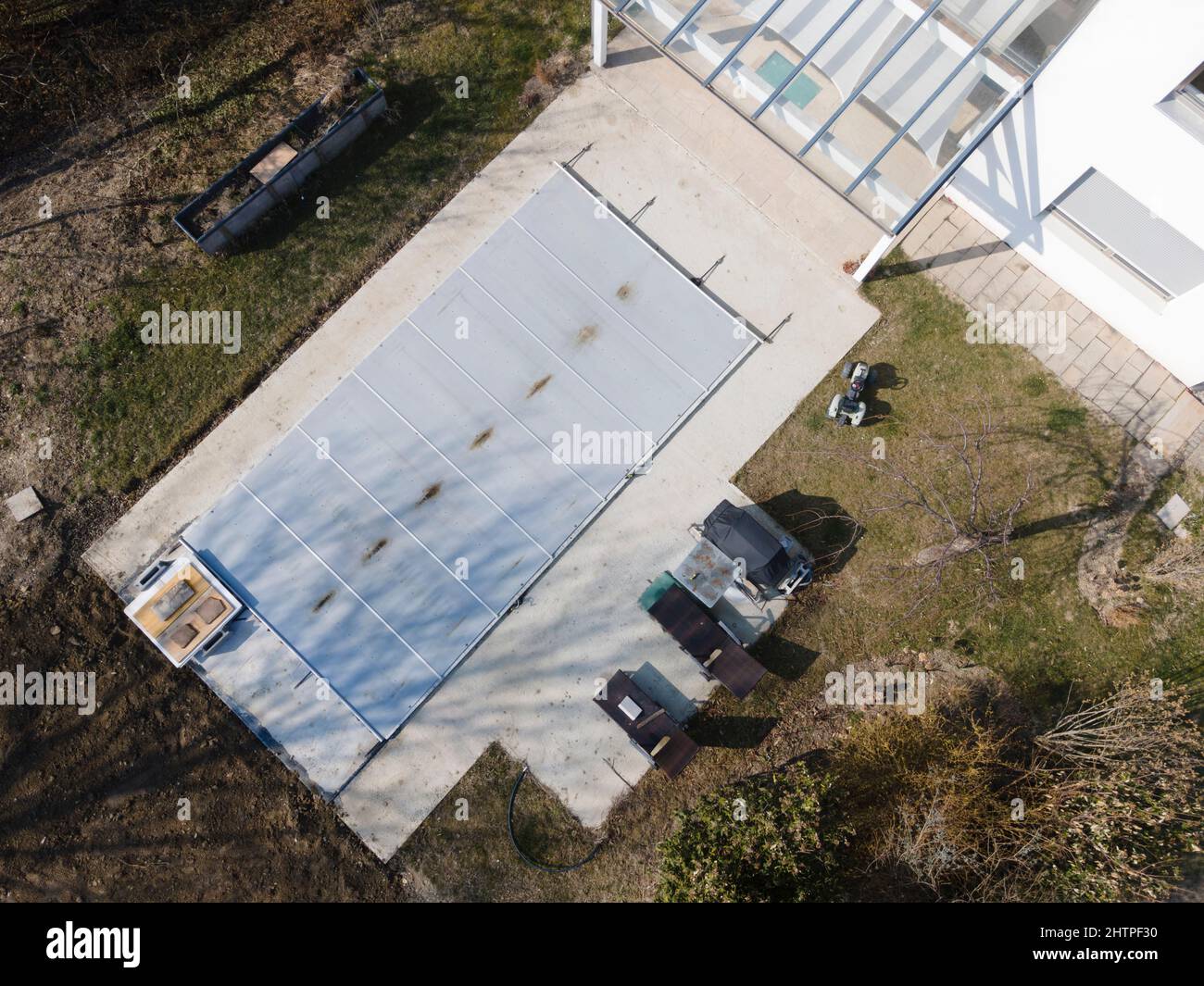 Un drone survolait une piscine couverte avec une bâche encore en construction dans un jardin Banque D'Images
