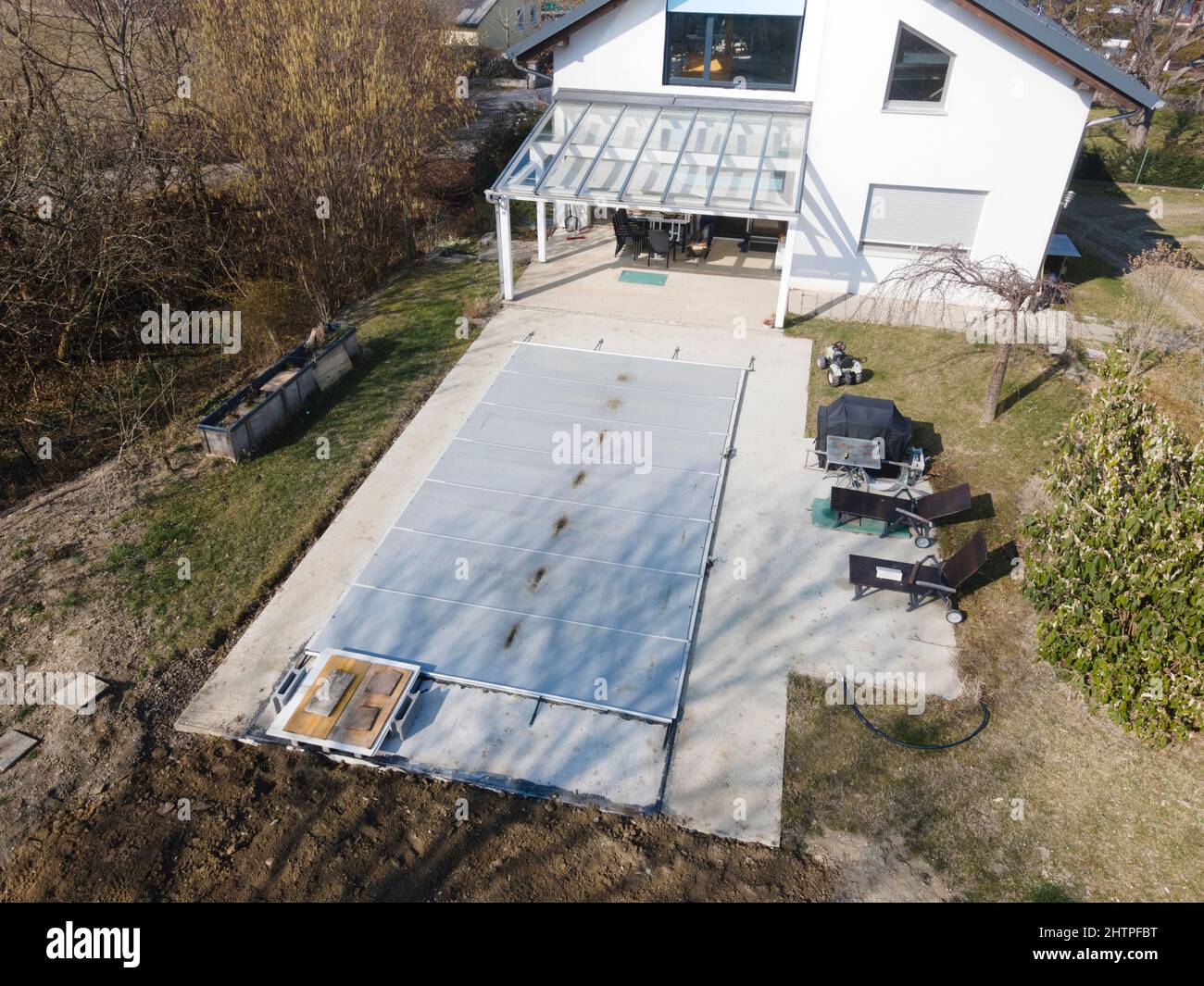 Un drone survolait une piscine couverte avec une bâche encore en construction dans un jardin Banque D'Images