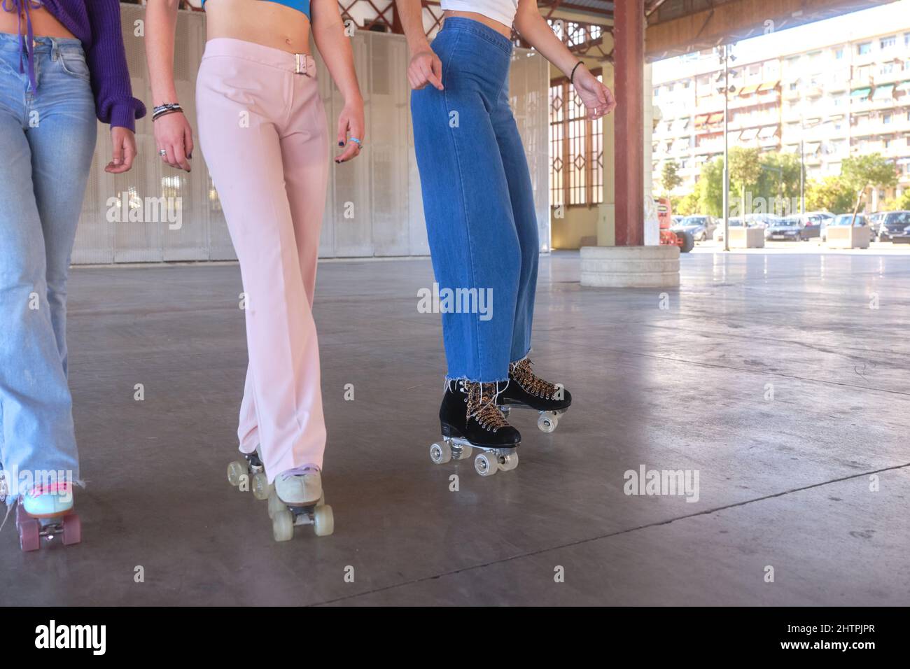Jambes de trois femmes patinant avec des patins classiques dans une zone urbaine Banque D'Images